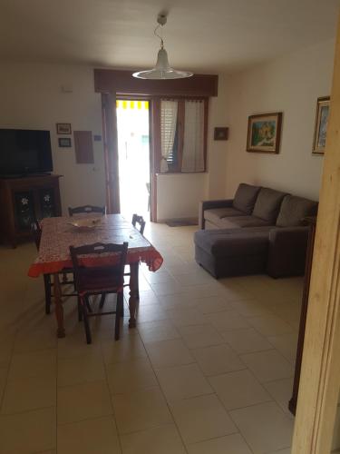 ein Wohnzimmer mit einem Tisch und einem Sofa in der Unterkunft Residenza Carone in Porto Cesareo