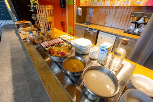 a kitchen with bowls of food on a counter at ibis budget Besançon Centre Gare in Besançon
