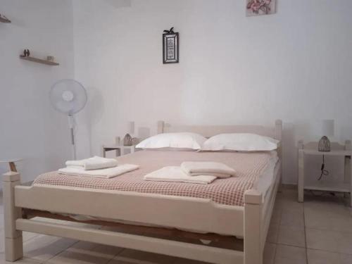 a white bedroom with a bed with towels on it at Argyro's vintage House in Spílion
