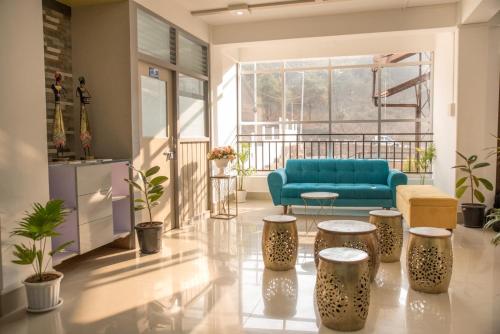 a living room with a blue couch and stools at MOCAHM in Shillong