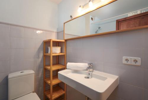 uma casa de banho com um lavatório, um WC e um espelho. em Cas Sitger em Felanitx