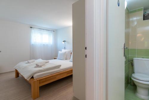 a small bedroom with a bed and a toilet at Apartment Hrabar Longo in Trogir