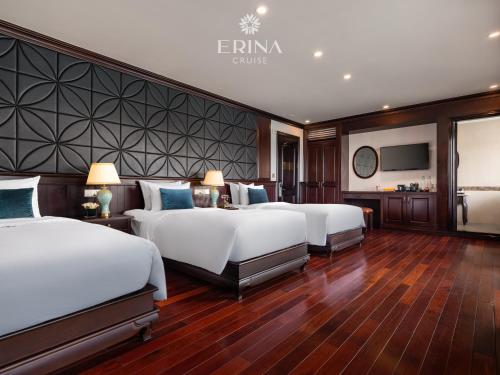 a hotel room with three beds and a television at Erina Cruise by HAG in Ha Long