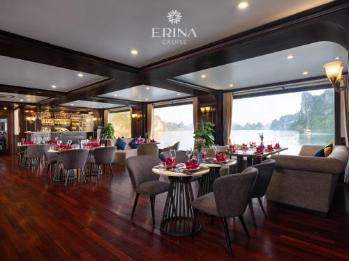 a restaurant with tables and chairs and a large window at Erina Cruise by HAG in Ha Long