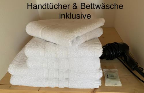 una pila de toallas sentadas en el suelo junto a un arma en Nr9Marinehafen - Ferienwohnungen, en Stralsund