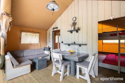 une petite maison avec une table à manger et un lit dans l'établissement Tente RENARD 5 PERSONNES CAMPING LOU CANTOU CEVENOL, à Anduze