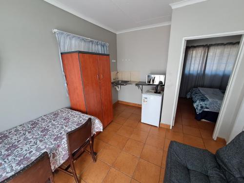 a small room with a table and a small kitchen at Woodhills Guest house in Piet Retief