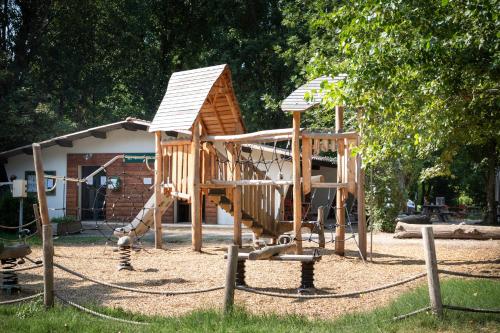 - une aire de jeux en bois avec toboggan dans la cour dans l'établissement Huttopia Millau, à Millau