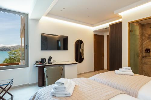 two beds in a room with a view of the ocean at Naiades Boutique Hotel - Adults Only in Elounda