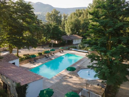 - une vue sur la piscine bordée de chaises et de parasols dans l'établissement Huttopia Millau, à Millau