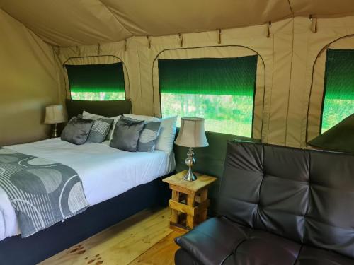 a bedroom with a bed and a couch in a tent at Villa Tarentaal in Tulbagh
