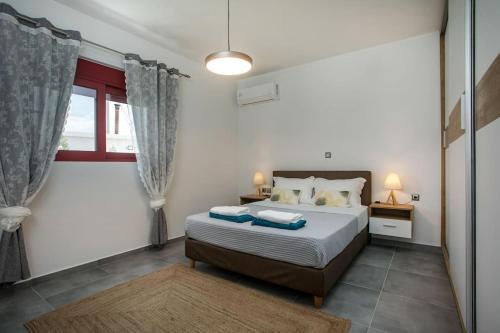 1 dormitorio con cama y ventana en SunDaLucky, en Afantou