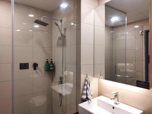 雲頂高原的住宿－TopGenting RedMarbleColdSty2R2B7Pax at GrdIonDelmn，浴室配有盥洗盆和带镜子的淋浴