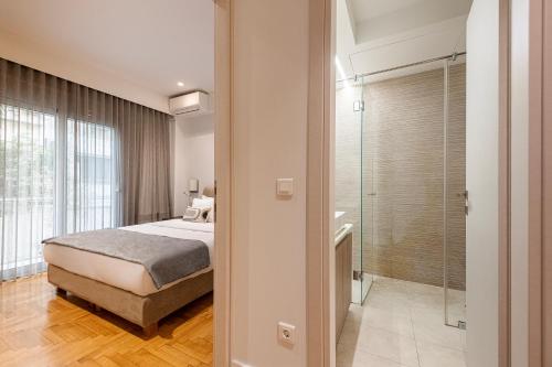 ein Schlafzimmer mit einem Bett und einer ebenerdigen Dusche in der Unterkunft Phaedrus Living: Executive Flat Kolonaki in Athen