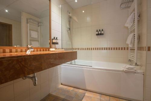 uma casa de banho com uma banheira e um lavatório e uma banheira em Hotel Màgic Ski em La Massana