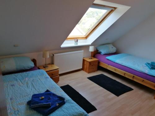 Schlafzimmer im Dachgeschoss mit 2 Betten und einem Fenster in der Unterkunft Ferienwohnung Gebken in Börgerwald