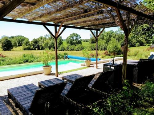 un patio avec des chaises et une piscine dans l'établissement Chateau Barayre - beautiful 12th century castle with pool and large garden, à Laussou