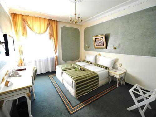 Pokój hotelowy z łóżkiem i biurkiem w obiekcie Queen's Astoria Design Hotel w Belgradzie