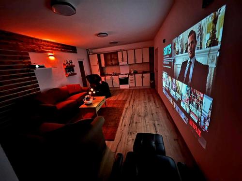 uma sala de estar com um sofá e uma televisão de ecrã plano em Cinema Relax Apartament em Pristina