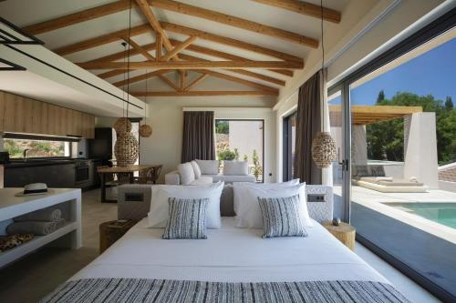 a bedroom with a large bed and a swimming pool at Amahle Luxury Villas 2023 in Andipáta Erísou