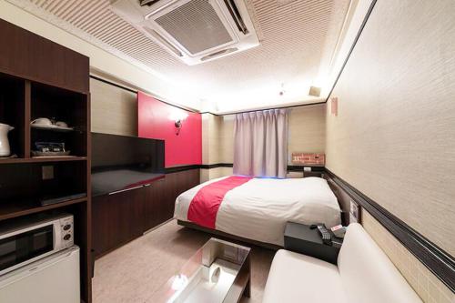 a hotel room with a bed and a tv at Hotel Next II-Adult Only in Sendai