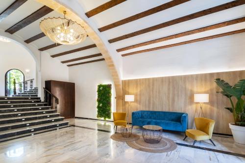 a lobby with a blue couch and chairs at Occidental Pueblo Acantilado in El Campello