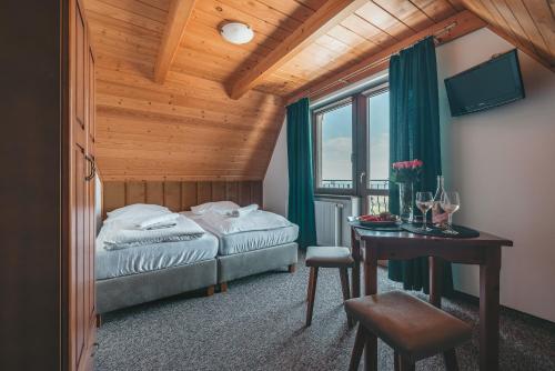 een slaapkamer met een bed en een bureau met een tafel bij Pokoje gościnne U Semlów in Bańska