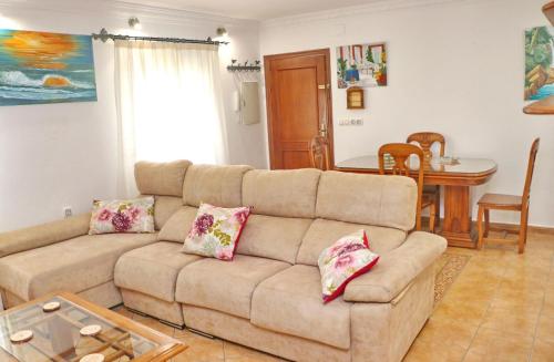 een woonkamer met een bank en een tafel bij Apartamento Acuario in Conil de la Frontera