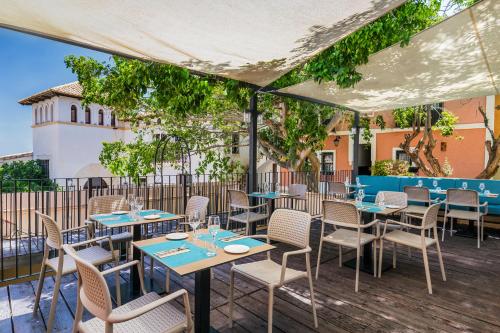 a restaurant with tables and chairs on a deck at Occidental Pueblo Acantilado in El Campello