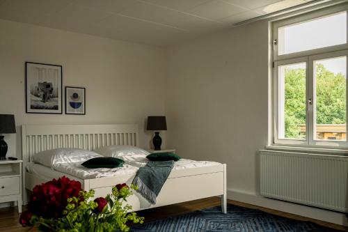 una camera bianca con un letto e una finestra di FeWo Anna a Weimar