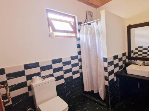 een badkamer met een toilet, een wastafel en een spiegel bij ITALIAN GUEST in Trincomalee