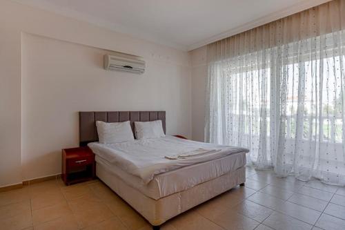 a bedroom with a bed and a large window at Private Pool,near to The Land of LEGEND in Belek