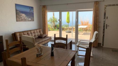 sala de estar con sofá, mesa y sillas en HRlos Piratas - Ferien Haus La Palma - GOOD WLAN !! en Tijarafe