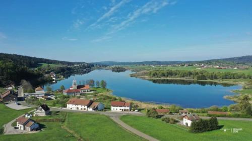 an aerial view of a village and a lake at Ecolodge, bain nordique, petit dejeuner in Fort-du-Plasne