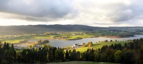 a view of a golf course with a lake at Ecolodge, bain nordique, petit dejeuner in Fort-du-Plasne