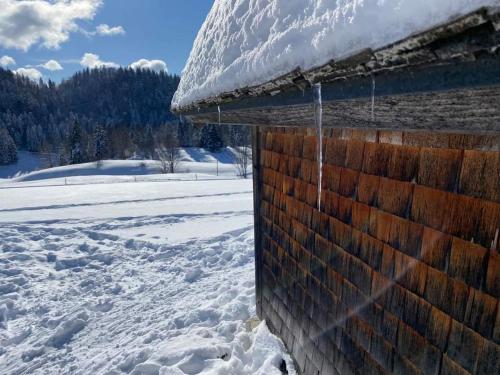 a icicle hanging from the side of a building in the snow at Ecolodge, bain nordique, petit dejeuner in Fort-du-Plasne