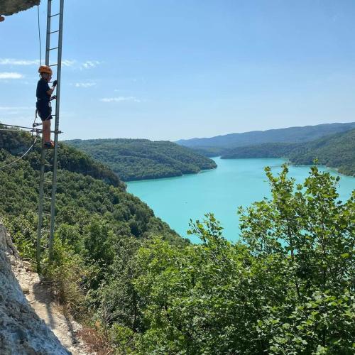 a person standing on a pole on a mountain overlooking a lake at Ecolodge, bain nordique, petit dejeuner in Fort-du-Plasne