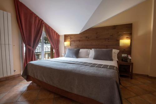 - une chambre avec un grand lit et une fenêtre dans l'établissement Hotel Màgic Ski, à La Massana