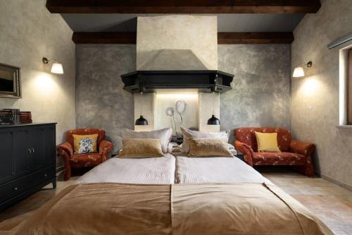 een slaapkamer met een groot bed en twee stoelen bij Apartman Ela Vi in Kršan