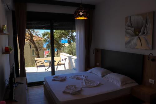 een slaapkamer met een bed en uitzicht op een patio bij Eagles Apartments & Suites in Ulcinj