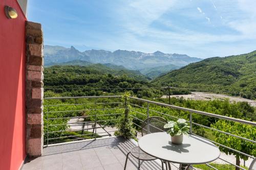 a balcony with a table and chairs and mountains at Gefiri Plakas Hotel, Tzoumerka in Plaka