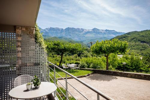 d'un balcon avec une table et une vue sur les montagnes. dans l'établissement Gefiri Plakas Hotel by Konnect, Tzoumerka, à Plaka