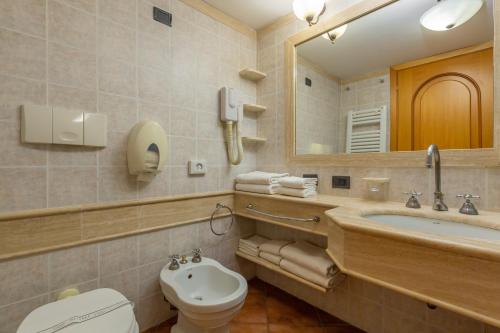 a bathroom with a sink and a toilet and a mirror at Carpediem Roma Golf Club in Marco Simone