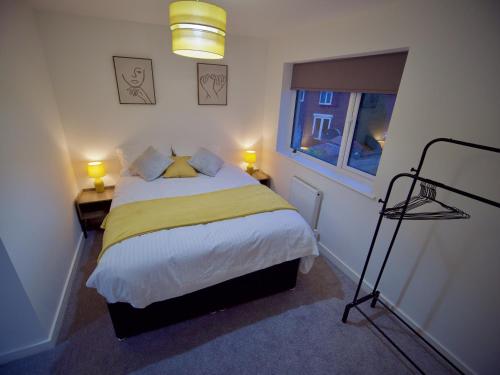 - une chambre avec un lit doté de draps jaunes et une fenêtre dans l'établissement Ideal Lodgings in Radcliffe, à Radcliffe