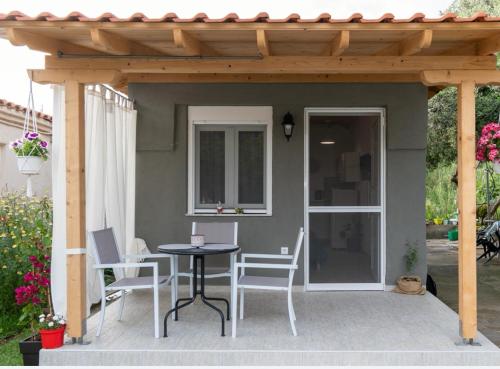 a patio with a table and chairs under a pergola at Ο ΚΗΠΟΣ ΤΗΣ ΕΔΕΜ in Toroni