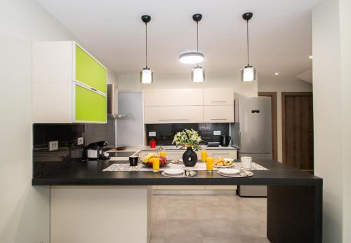 a kitchen with white cabinets and a black counter top at Hypatia Suites in Zakynthos Town