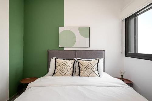 1 dormitorio con paredes verdes y blancas y 1 cama en Mate ALLENBY - By HOMY, en Tel Aviv