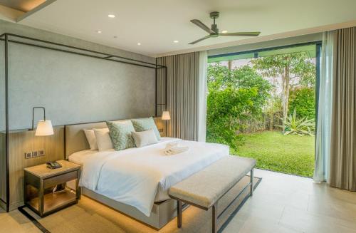 een slaapkamer met een bed en een groot raam bij Discovery Samal in Samal