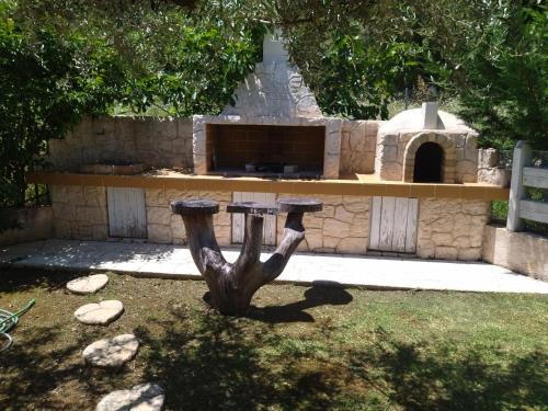 a stone pizza oven with a statue in front of it at Theonymfi Luxury Villas in Doukádes