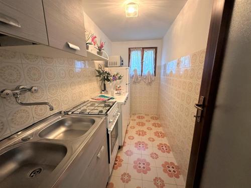 a small kitchen with a sink and a stove at Villa Luisa in Lignano Sabbiadoro